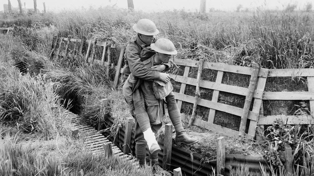 Medic carrying soldier in trenches during WWI 